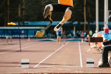 athlete amputee on prosthetic leg long jump competition at athleticsの写真素材