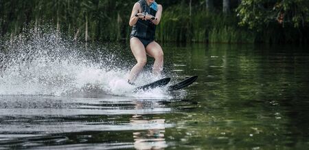 wakeboarding female rider in wakeboard in summer on lakeの写真素材