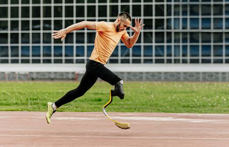 physically disabled athlete running with prosthetic legsの写真素材