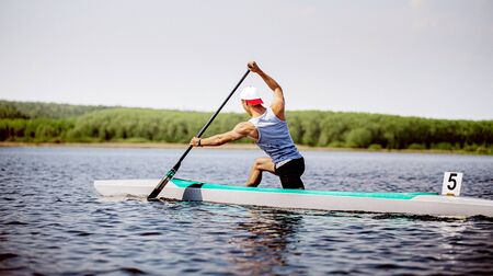 men canoeist rowing in lake. canoeing competition race