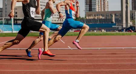 men sprinters run on track stadium in athletics competitionの写真素材