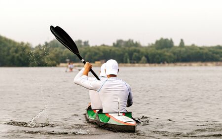 back two kayakers paddling kayak in competition raceの写真素材