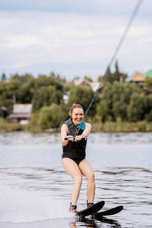 smiling girl on water skiing riding on lakeの写真素材