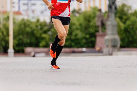 man runner in black compression socks running city marathon