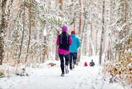athletes runners running winter trail marathon in forest during a snowfallの写真素材