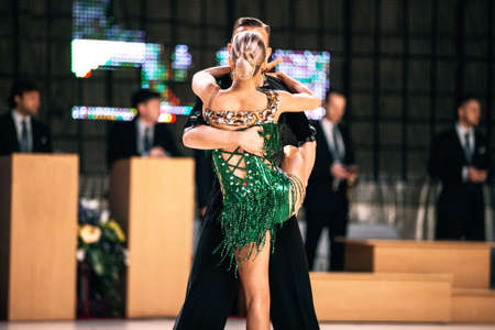 couple dancers latin dancing in background referee