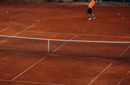 male tennis player training serve on tennis courtの写真素材