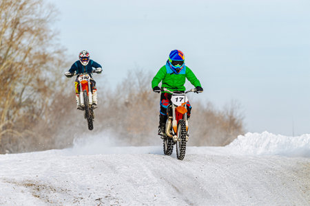 two motorcyclists riding on snowy trail winter motocross