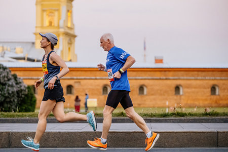 Saint Petersburg, Russia - June 11, 2022: female and old male athlete running Marathon White Nights