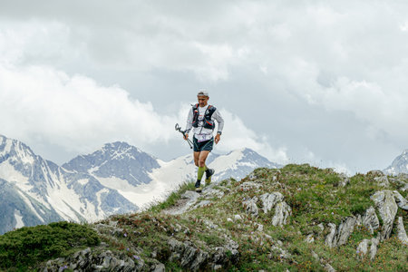 Arkhyz, Russia - July 2, 2022: male athlete running mountain trail in Arkhyz X Run