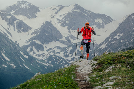 Arkhyz, Russia - July 2, 2022: male athlete walking mountain trail in Arkhyz X Run