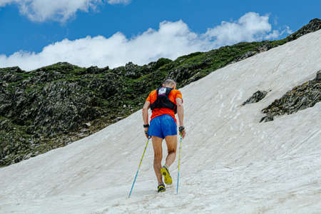 male athlete climbing snowy uphill during an ultra marathon