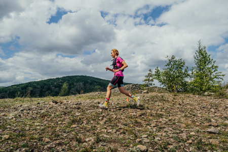 Bannoe, Russia - July 31, 2022: female athlete run trail along crest mountain in MMK Wild Trailのeditorial素材