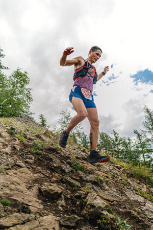 Bannoe, Russia - July 31, 2022: man runner run steep mountain descent in MMK Wild Trailのeditorial素材