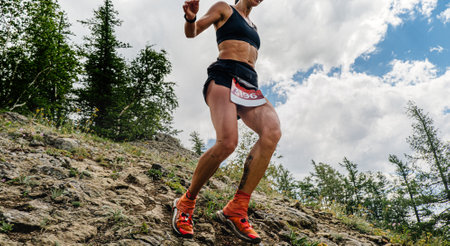 female runner running down mountain trail