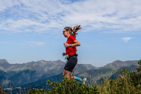 Rosa Khutor, Russia - September 10, 2022: female athlete running down steep mountainside in Rosa Wild Trailのeditorial素材