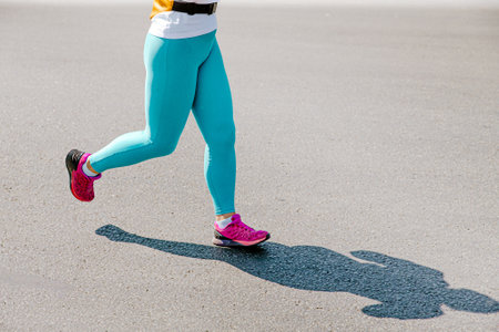 girl runner in turquoise leggings running raceの写真素材