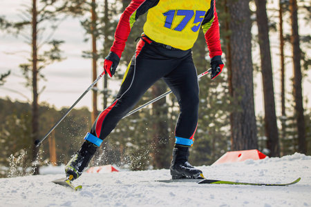 close-up male athlete skier running cross country skiing, on legs frid tag to control resultの写真素材