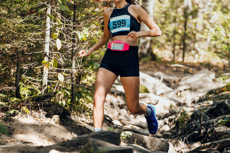 girl runner athlete running stones trail marathon race in forestの写真素材