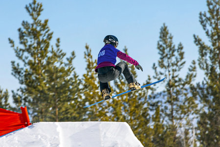 female snowboarders jumping drops in snowboarding competition, winter sportsの写真素材