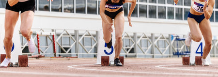 three women athletes runners start running sprint race in summer athletics championshipsの写真素材
