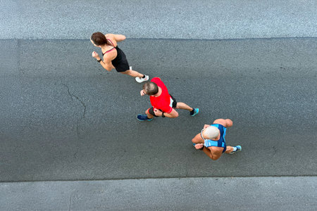 woman and male runner running asphalt road, top-down viewの写真素材
