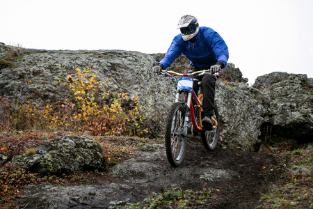 mountain biker riding on dirt path during downhill competition