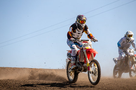 Two motocross rider riding on dusty track
