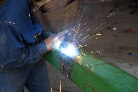 May, 2006.  Parkhill, Ontario, Canada.  A farmer welds a patch onto a guide of his planter. 