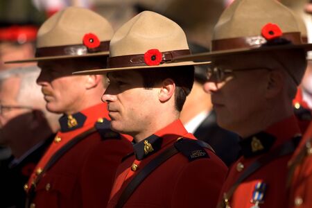 London Ontario, Canada - November 11, 2011. RCMP officers with poppies in their signature stetsons during Remembrance Day ceremonies at the Cenotaph in Victoria Park in London Ontario Canada. のeditorial素材