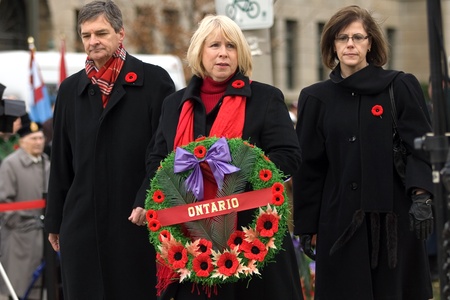 London Ontario, Canada - November 11, 2011. From left to right, Ontario Liberal's Chris Bentley and Deb Matthews are joined by Ontario NDP member Teresa Armstrong as they prepare to lay a wreath during Remembrance Day ceremonies at the Cenotaph in Victoriのeditorial素材