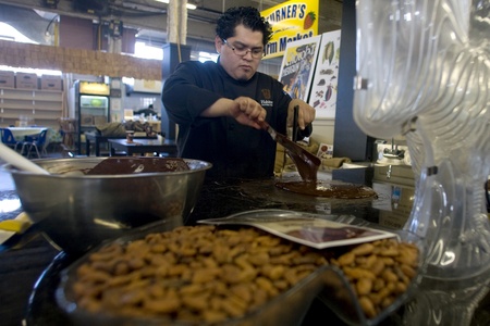 London Ontario, Canada - April 5, 2012. Daniel Cortes of Habitual Chocolate in London tempers chocolate on a marble table. The process of tempering produces a product that is stable enought to be poured into molds. のeditorial素材