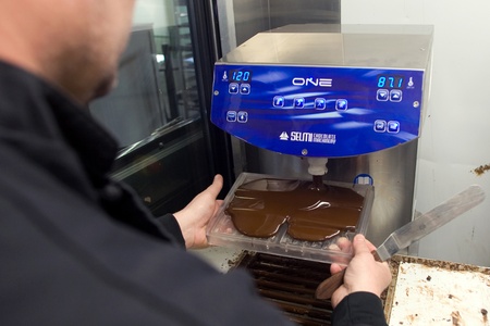 London Ontario, Canada - April 5, 2012. David Cook owner of Habitual Chocolate in London Ontario pours chocolate into a mold. のeditorial素材