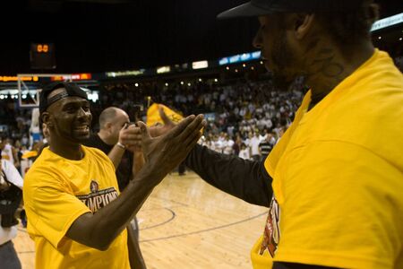 London Ontario, Canada - March 25, 2012. DeAnthony Bowden, left and Gabe Freeman celebrate after winning the league championship.のeditorial素材
