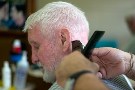 London Ontario, Canada - March 28, 2012. Vincenzo Ioele owner of "Vince's Barber Shop" at 780 Dundas Street in London cuts the hair of George Stovel a regular customer. Ioele opened the shop in 1980 and has been in the same location since then. He has a rのeditorial素材