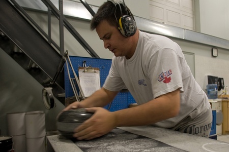 April 26, 2012. Wayne Tuck completes on the last steps in refinishing a curling rock. By turning the rock on coarse sand paper will help to break the rock in. If the curling rock was shipped as a polished surface the rock would not curl at all. Canada Curのeditorial素材