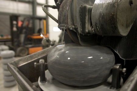 April 26, 2012. A curling rock has its running surface carved into it by a diamond tipped lathe. In order of rocks to perform in similar way, the running surface on each rock needs to be consistant. Canada Curling Stone in Komoko Ontario, near London is oのeditorial素材