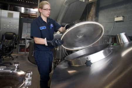 Toronto Ontario, Canada - June 5, 2012. Erica Graholm a brewer at Steam Whistle opens a Lauter Tun used to perform specific gravity test that measures fermentable sugars during the brew-in process. Located in a former Canadian Pacific Rail steam locomotivのeditorial素材