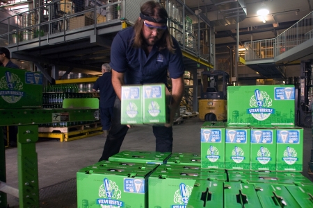 Toronto Ontario, Canada - June 5, 2012. Eric Kaluzny stacks cases onto a pallet for shipment. Steam...