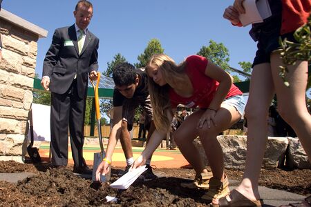 London, ON  June 26, 2012  Students from Masonville Public School place seed paper which they wrote essays on into the ground. The seed paper will break down in the soil and bloom into a plant. The TD Green Energy Park in London, Ontario. The park powerのeditorial素材