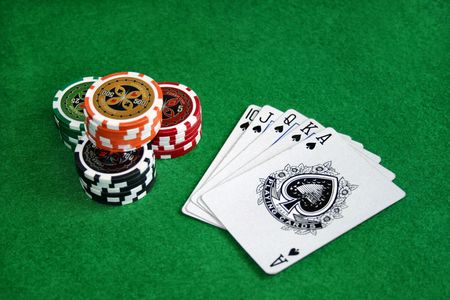 Poker chips with playing cards on green feltのeditorial素材