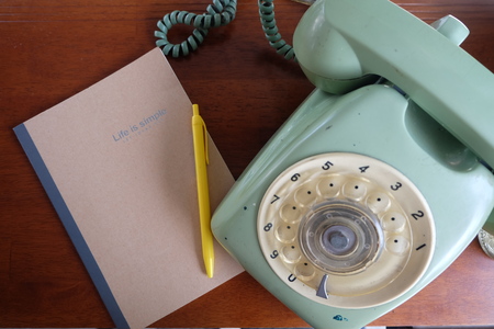 old telephone and notebook on tableの写真素材