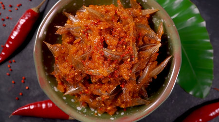 Spicy chili in a small bowl. Malaysia's local food Sambal is a spicy sauce made by deep frying small anchovies and chili paste.の写真素材
