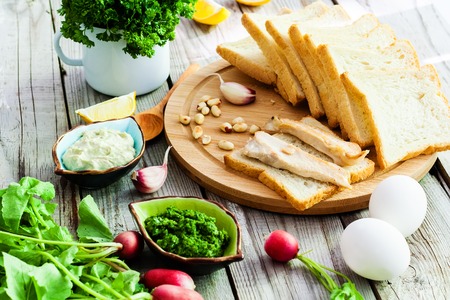 Top view foodstuffs for sandwiches on wooden background.
