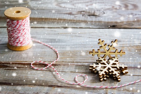Snowflakes and red bakers twine on wooden background. Winter holidays concept.の写真素材