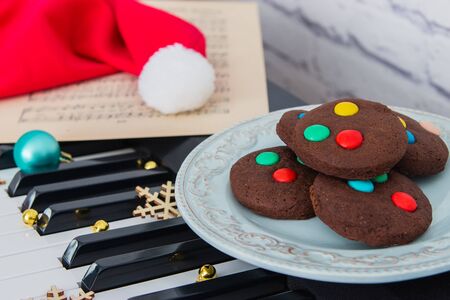 Christmas cookies and santa's red hat on piano.の写真素材
