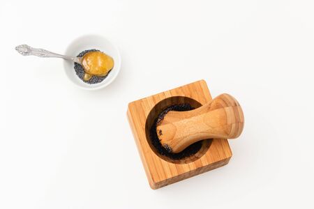 Poppy seed in pounder and honey teaspoon
