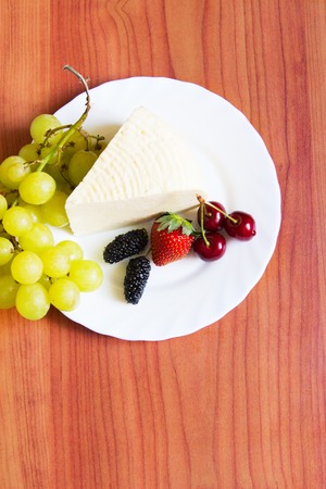 Wedge Adygea cheese summer berry healthy food wooden table.の写真素材