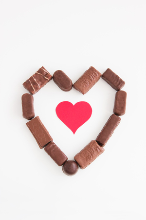 Valentines background with chocolate heart and cardboard hearts.の写真素材