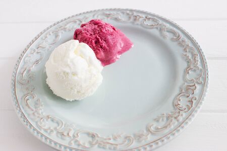 Blue pottery plate two balls ice cream kitchen wooden table selective focus.の写真素材